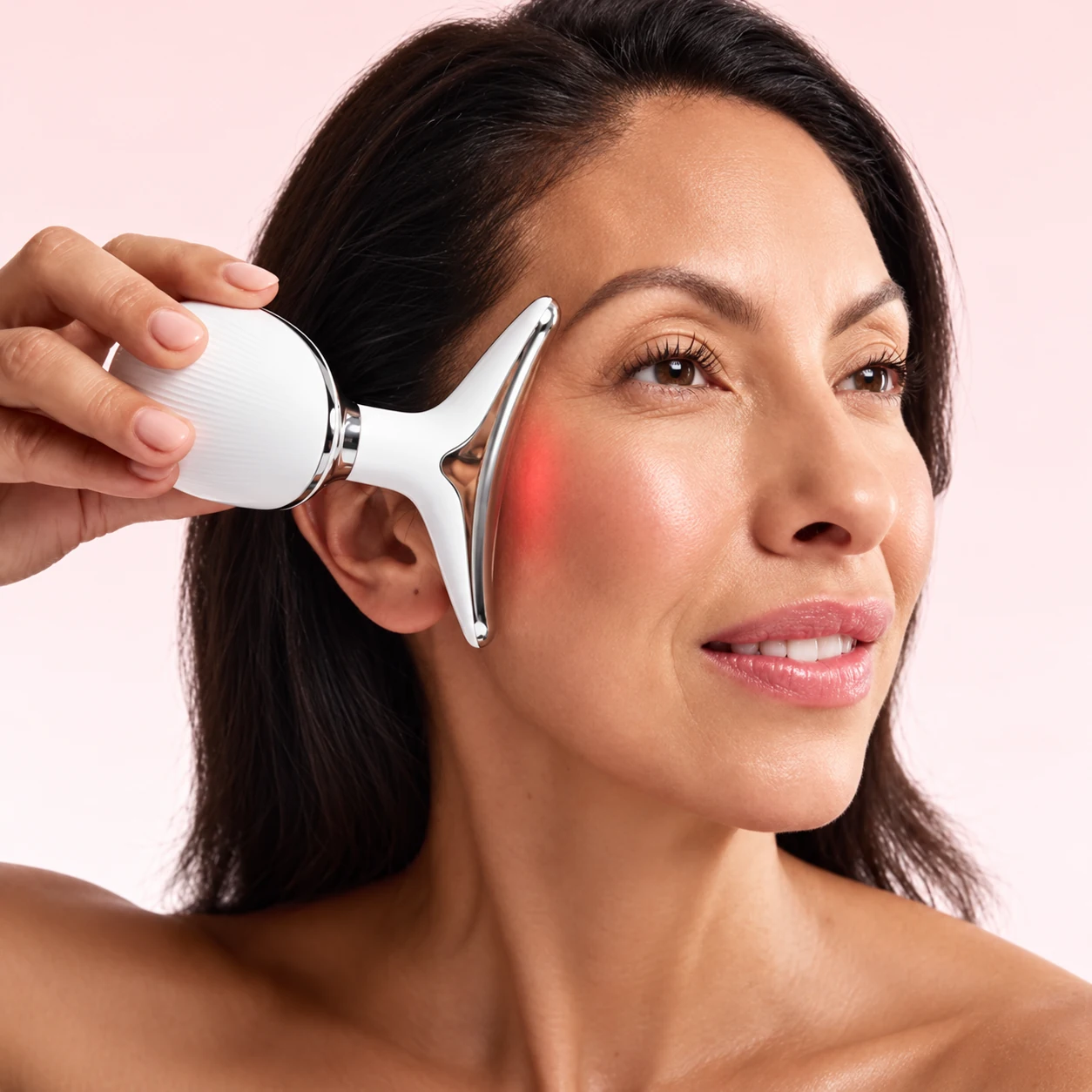 Woman using the ZAYACO facial beauty device on her cheek